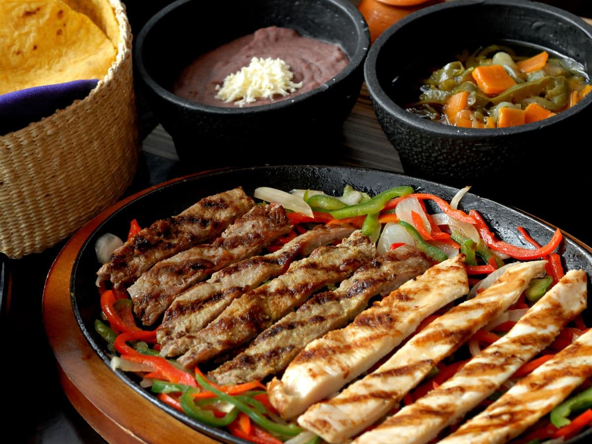 Sizzling steak and chicken fajitas with peppers and onions